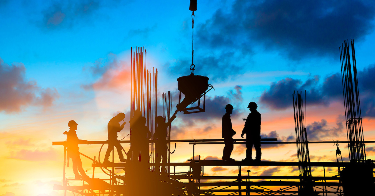 Group of construction workers in a construction site with the afternoon sky in the background