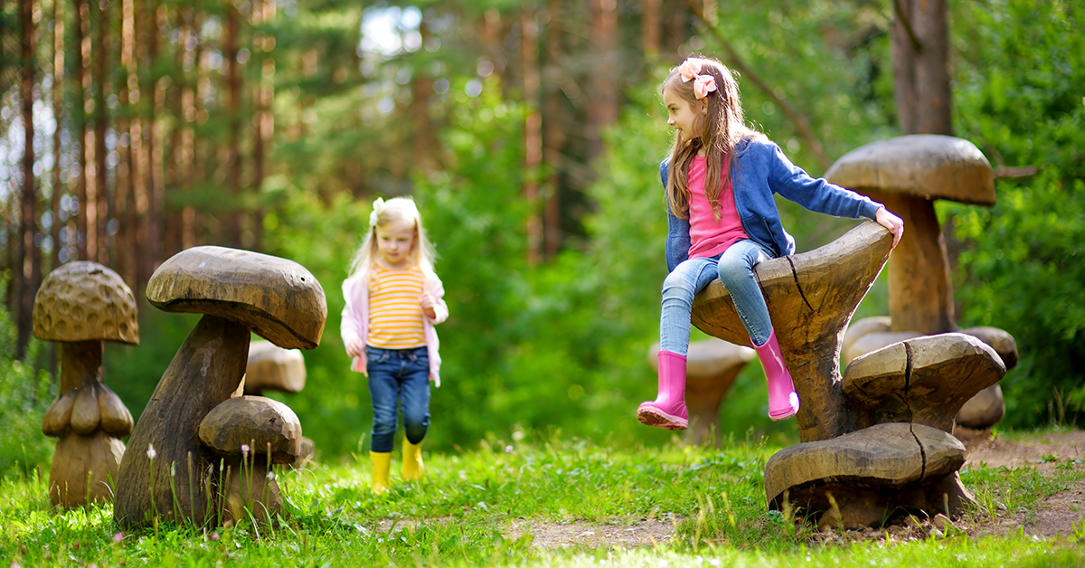 Two little girls playing in a forest